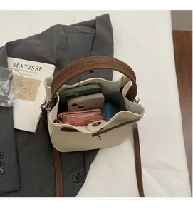 Vue de dessus montrant la grande capacité intérieure du sac seau bicolore avec accessoires