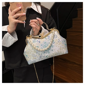 Detail of vintage embroidery floral handbag with gold frame and pearl handle