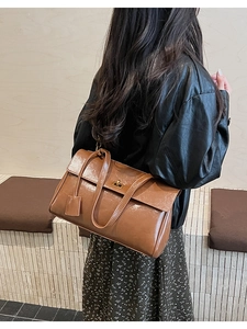 Detailed back view of a brown vintage leather handbag with a gold metallic twist lock