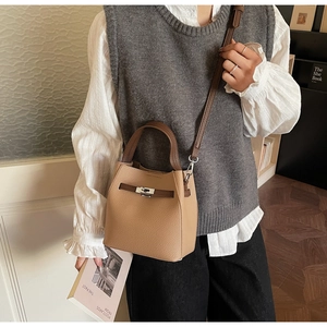 Détail du sac seau en cuir grainé kaki avec fermoir métallique et poignée marron