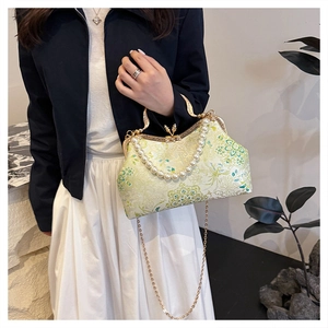 Detail of mint green cheongsam bag with floral embroidery and pearl handle accessory