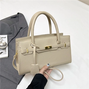 Elegant apricot lychee leather Kelly style handbag with golden twist lock and shoulder strap