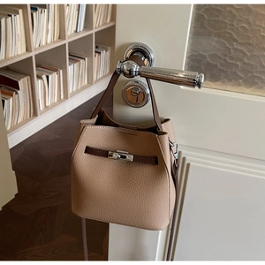 Détail du sac seau camel avec garniture en cuir marron et fermoir argenté sur porte