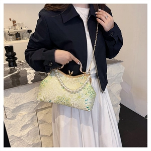 Detail of floral brocade evening bag with pearl handle and golden chain strap
