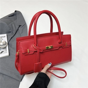 Red lychee pattern Kelly style handbag with gold turn-lock and adjustable shoulder strap