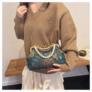 Detailed view of vintage embroidery evening bag with pearl handle and gold chain
