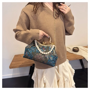 Detailed embroidery on vintage blue satin frame bag with pearl handle and gold chain