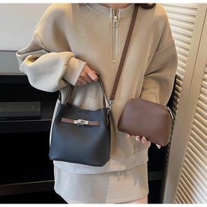 Détail du sac seau en cuir grainé noir avec fermoir argenté et petite pochette