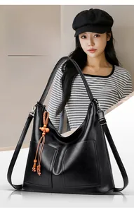 Détail du sac cabas en cuir noir avec fermeture éclair en corde et perles en bois