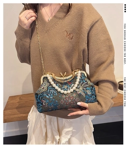 Detailed view of navy embroidery evening bag with pearl handle and floral patterns