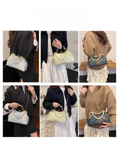 Detail of embroidered evening bag with pearl handle and metal chain for multiple carrying styles