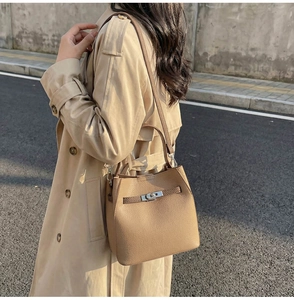 Détail d'un sac cabas en cuir motif lychee avec boucle argentée à la lumière du jour