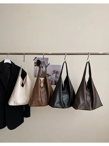 Litchi texture leather tote bags in cream, brown, black, and coffee hung in a row