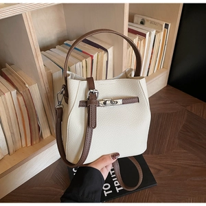 Détail du sac cabas en cuir grainé avec fermoir rotatif en argent sur une étagère