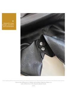 Detail of a black leather bag featuring a functional silver magnetic clasp closure