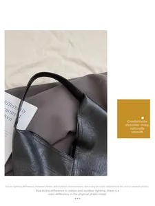Close-up of the reinforced stitching and soft leather texture on a black tote bag