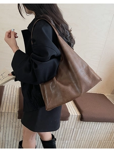 Macro detail of brown leather tote showing vintage textured leather and soft drape
