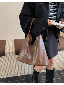 Detailed view of brown vintage leather tote bag showing soft texture and side stitching
