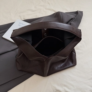 Macro view of dark brown tote bag interior with zipper pocket and magnetic snap closure