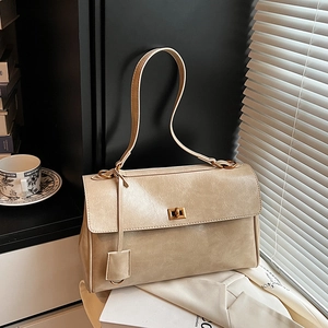 Retro cream beige shoulder bag with gold hardware and textured finish in elegant setting