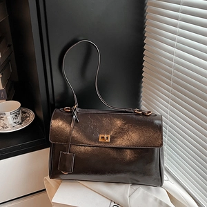 Retro polished dark leather tote bag with gold swivel lock and elegant shadow lighting