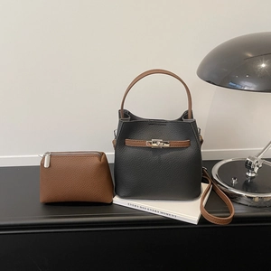 Sac seau minimaliste en cuir grainé noir avec anses marron et fermoir argenté