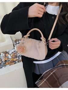Detail der Plüsch-Handtasche mit Ledergriff und süßem runden Bommel-Anhänger Accessoire