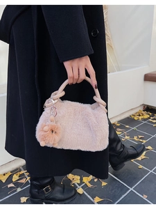 Detail einer Plüschhandtasche aus Kunstpelz mit Ledergriff und süßem Tieranhänger im Herbst