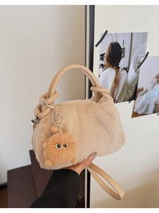 Detail der flauschigen beigen Handtasche mit weichem Kunstfell und niedlichem Anhänger