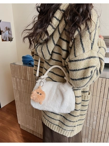 Detailansicht der weißen flauschigen Plüschtasche mit braunem Kunstpelz-Anhänger