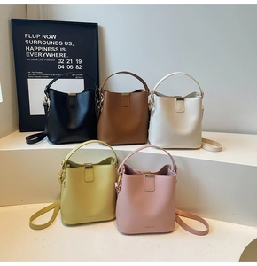 Group display of leather bucket bags in five colors with matte finish and metallic buckles