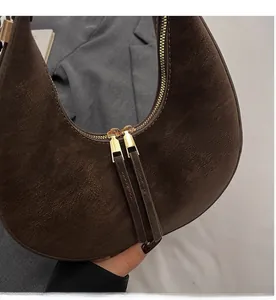 Dettaglio della borsa hobo in pelle scamosciata marrone con doppia zip in metallo dorato