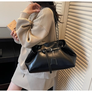 Vue détaillée du sac cabas en cuir verni noir avec boucle élégante et bandoulière