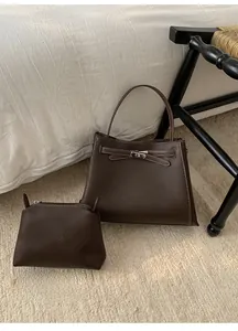 Détail du cabas en cuir grainé marron foncé avec fermoir argenté et petite pochette