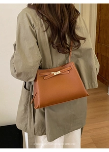Sac bandoulière en cuir grainé marron avec sangle à boucle vu de dos sur modèle