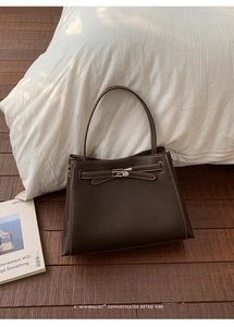 Détail du sac à main en cuir grainé marron avec fermoir métallique et coutures contrastées