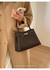 Détail du sac à main marron café en cuir grainé avec fermoir pivotant et surpiqûres blanches
