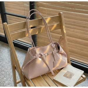 Sac fourre-tout en cuir PU rose avec boucle sur une chaise sous la lumière rayée