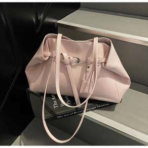 Gros plan du sac bandoulière en cuir rose pâle avec boucle et détails plissés