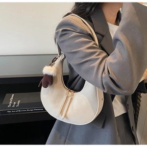 Borsa a mezzaluna crema con cerniera e ciondolo a forma di guanto in peluche marrone