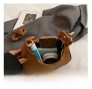 Vista interna della borsa a mezzaluna in pelle marrone con spazio per trucco e cellulare