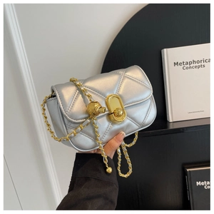 Close-up of silver quilted chain bag with gold sphere detail and metallic turn-lock