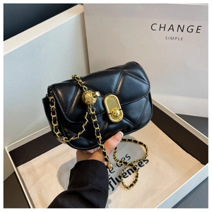 Detail of black quilted leather shoulder bag with gold metal ball and chain strap