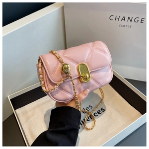 Detailed view of a pink quilted crossbody bag with gold chain and oval metal clasp