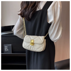 Detailed view of beige quilted leather crossbody bag with gold-tone twist lock and chain