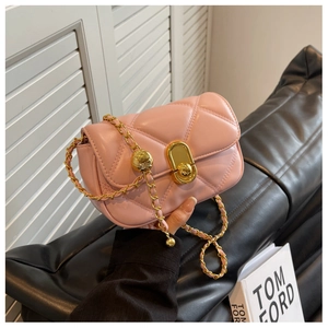 Detail of pink quilted leather bag featuring gold ball chain strap and metallic lock