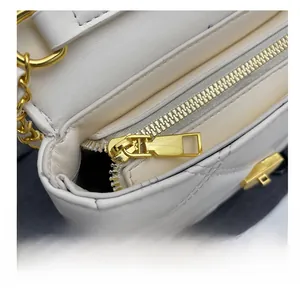 Detail shot of smooth gold zipper and white quilted leather on the chain shoulder bag