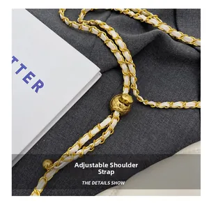 Detail of adjustable golden ball buckle on a white leather and chain shoulder strap