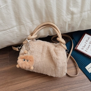 Schicke aprikosenfarbene Plüsch-Handtasche mit flauschiger Textur und Bärchen-Anhänger