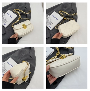 Detail view of white quilted leather bag with gold chain strap and metal turn-lock